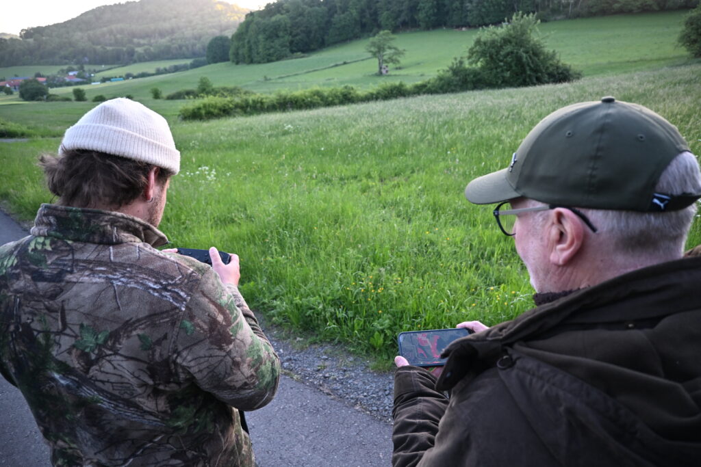 Drohnenpilot Christopher Hüfner (links) prüft mit der Thermaldrohne die Wiese und Werner Henkel (rechts) unterstütz bei der Flächentzuordnung. Foto: Matthias Bender